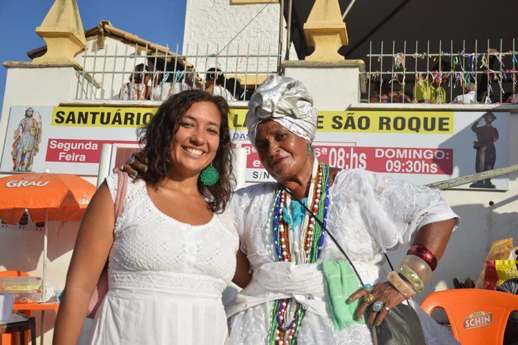 Two women stand outside on a sunny day