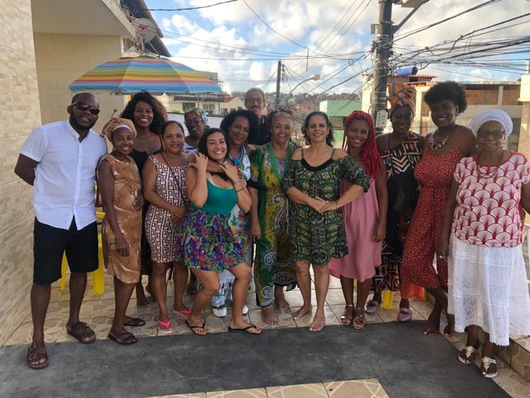 A group of people stand outside on a sunny day in Brazil